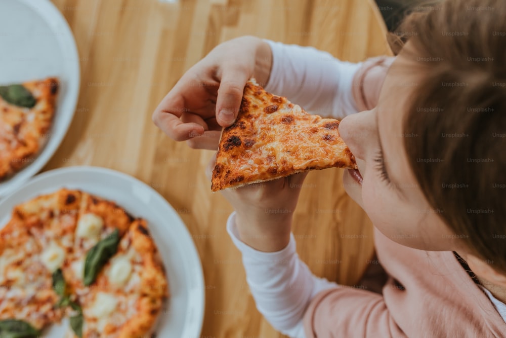 uma menina que come uma fatia de pizza