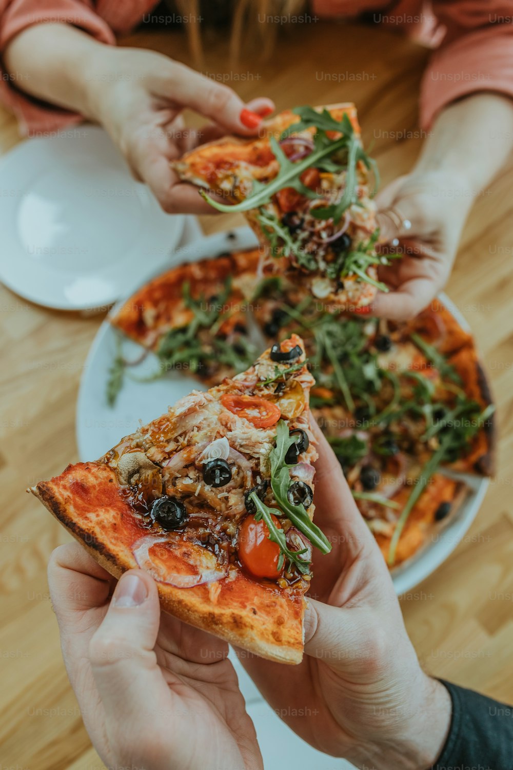 Una persona sosteniendo una rebanada de pizza en un plato