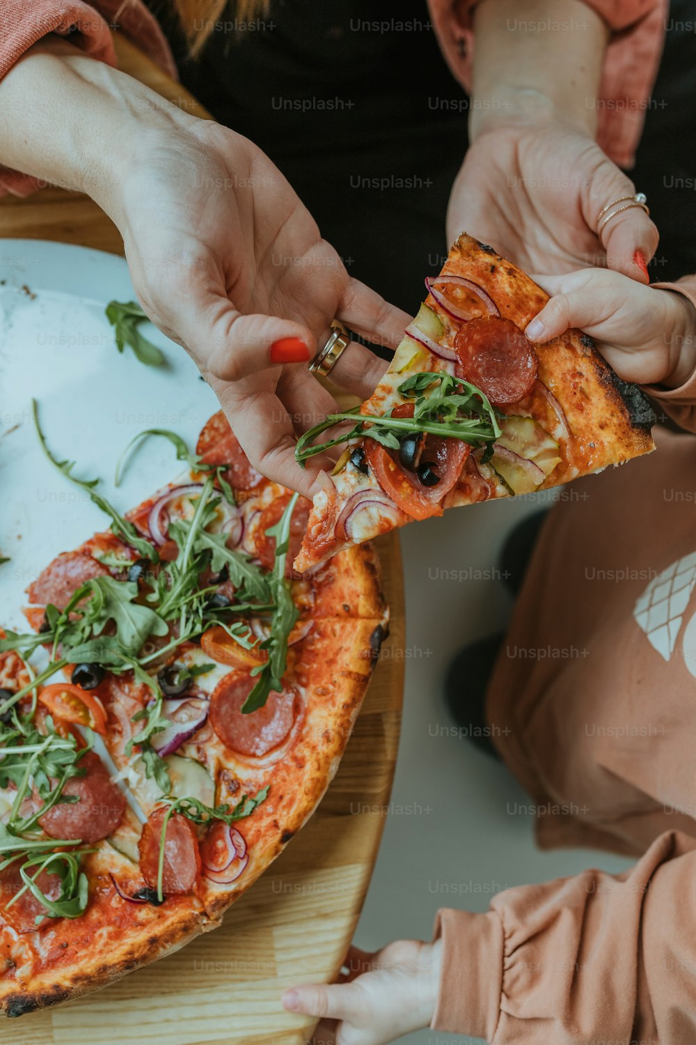 Una donna sta prendendo una fetta di pizza