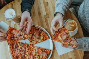 un paio di persone che stanno mangiando una pizza