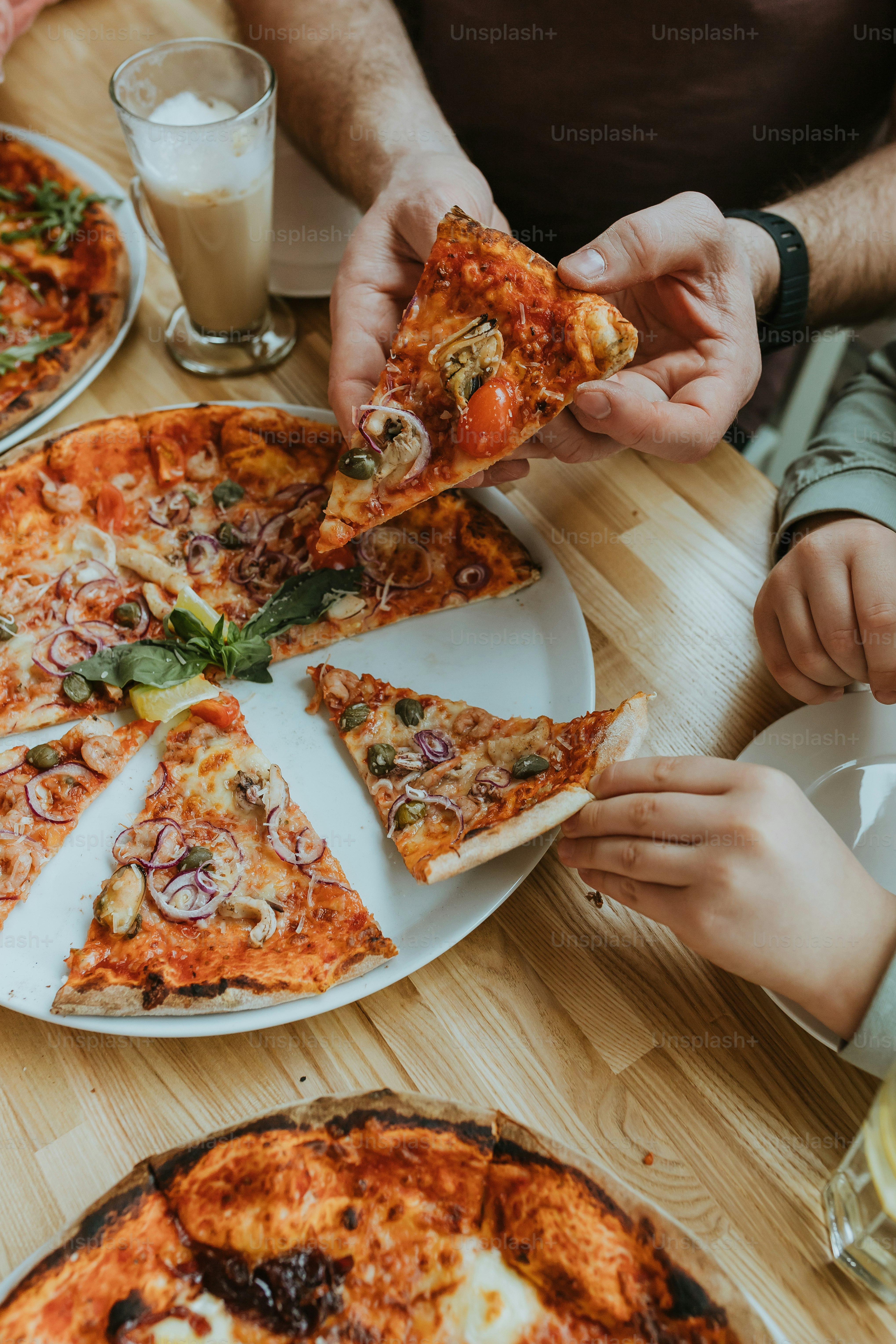 a group of people sitting around a table eating pizza