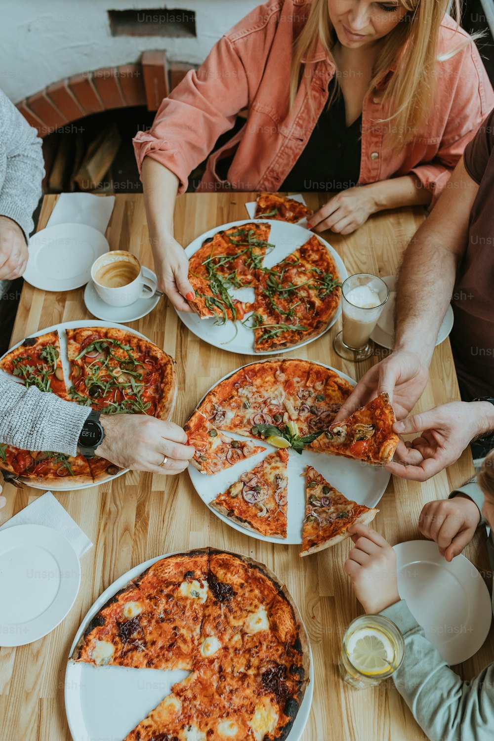 ��피자와 함께 테이블 주위에 앉아있는 사람들의 그룹