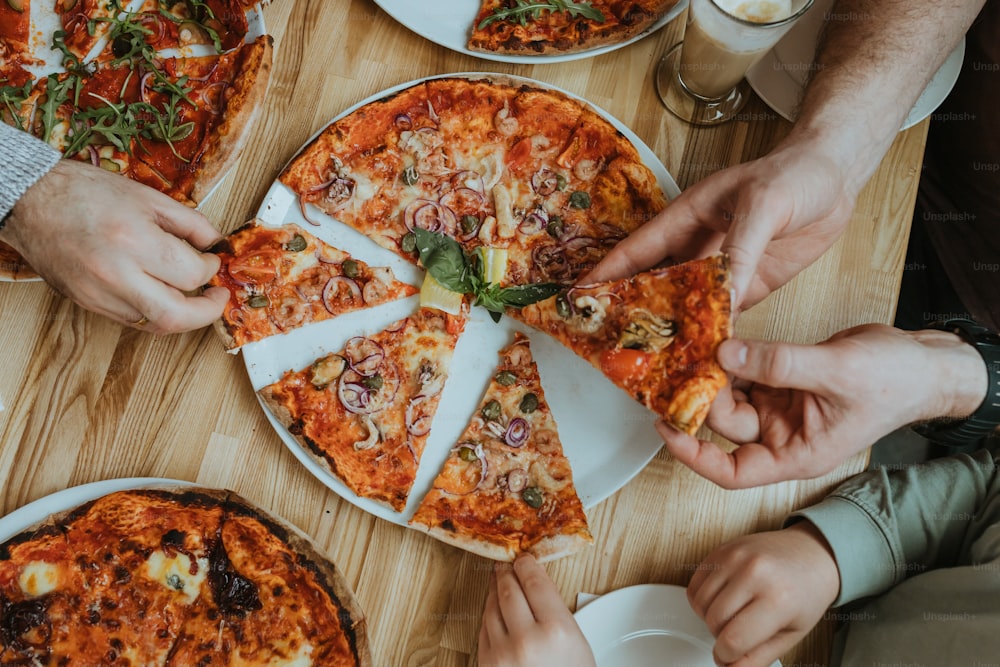 a group of people eating pizza at a table