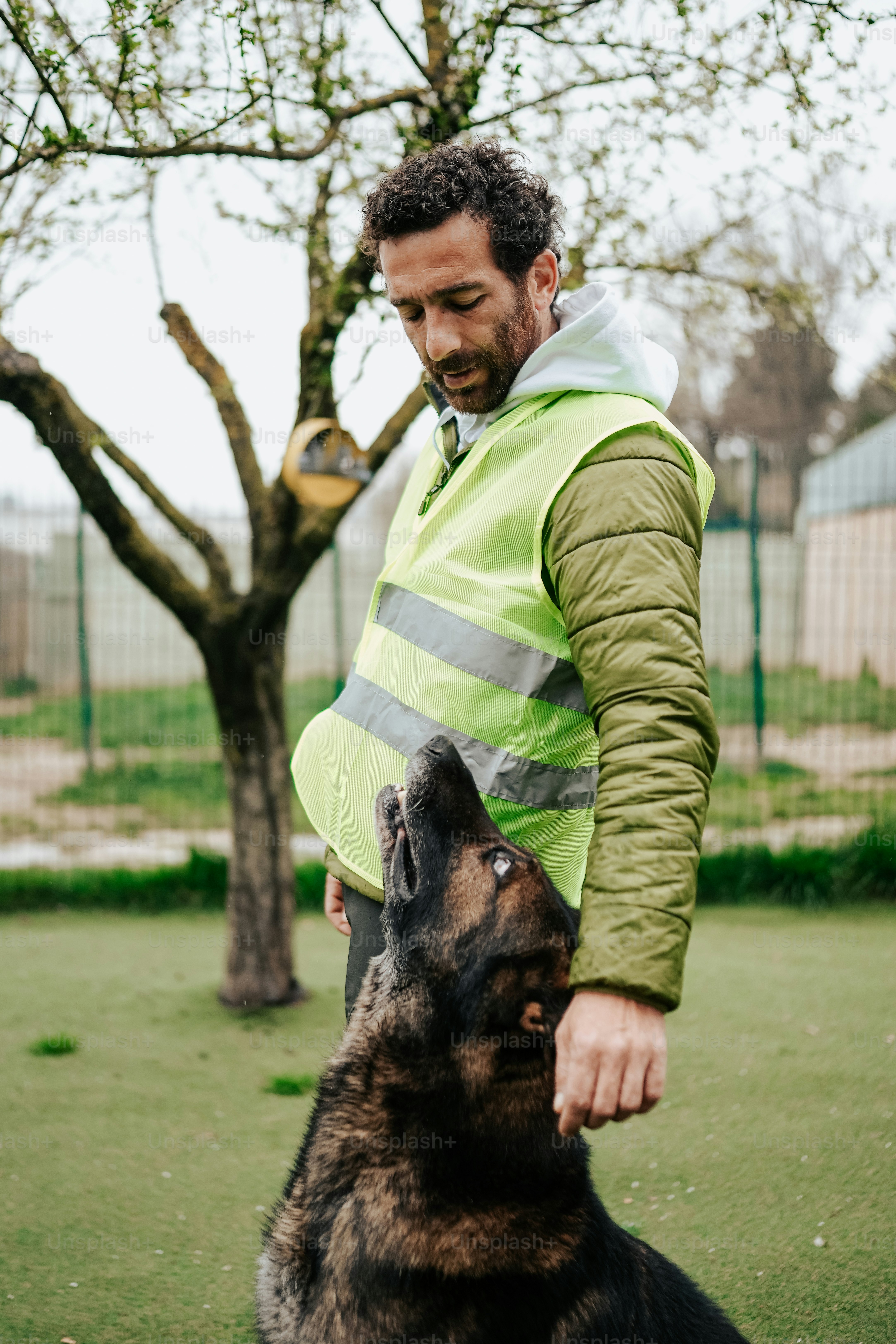 a man standing next to a black and brown dog