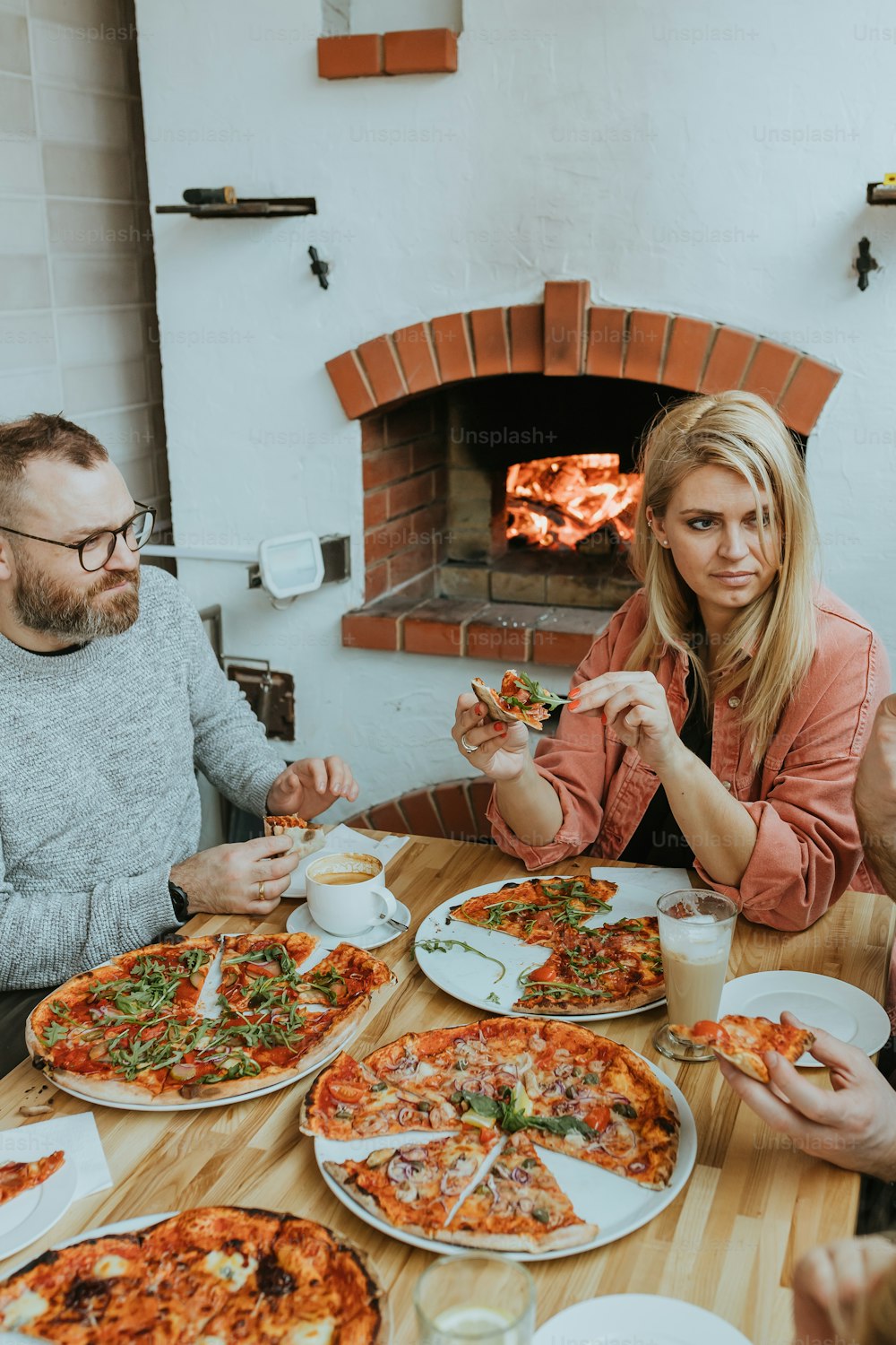a group of people sitting around a table eating pizza