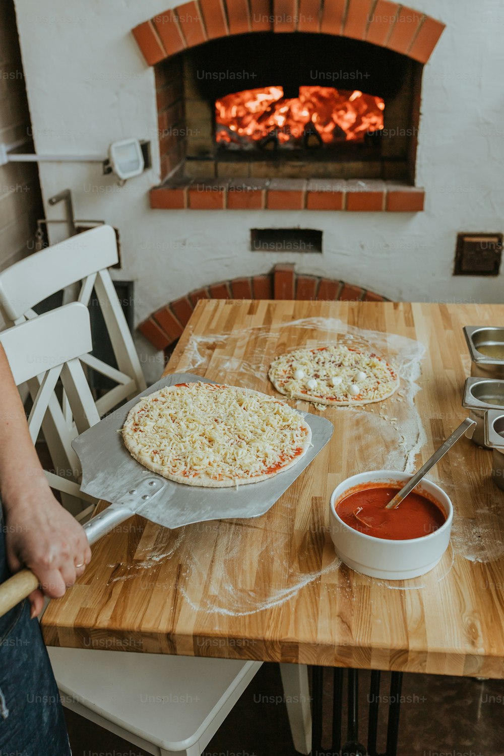나무 테이블 위에 앉아있는 두 개의 피자