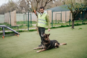 a man standing next to a dog on top of a green field