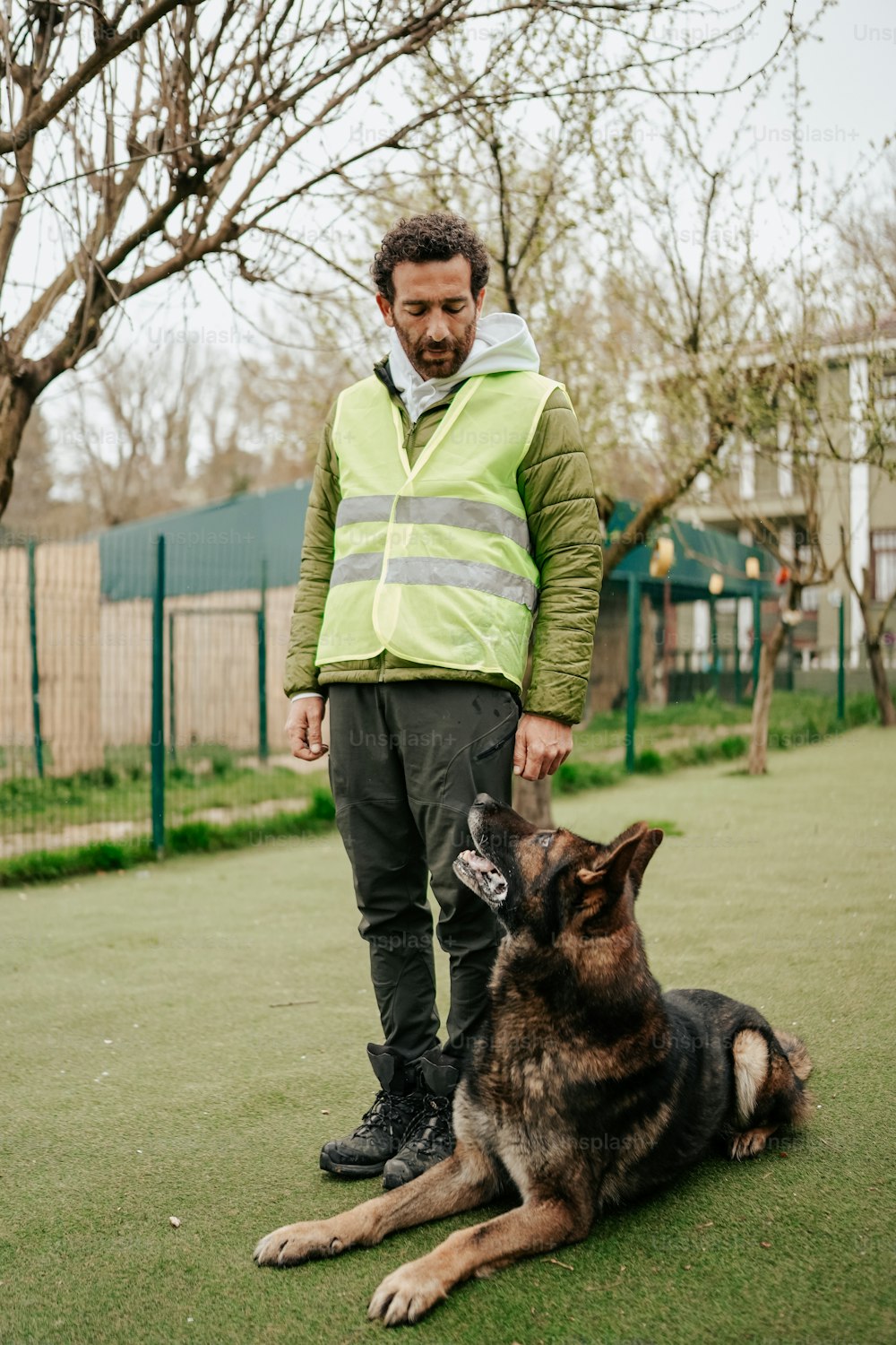 a man standing next to a dog on a lush green field