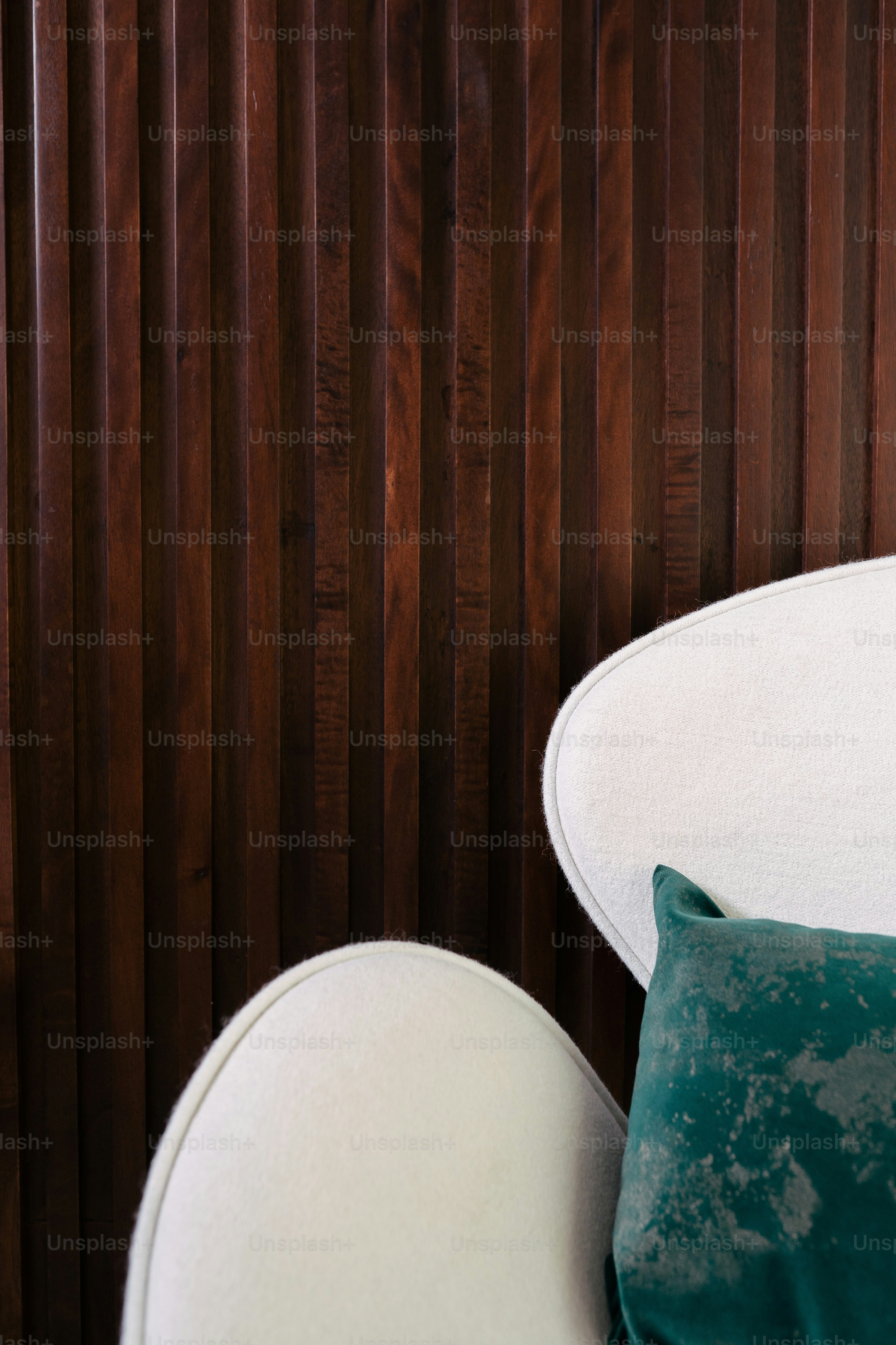 une chaise blanche avec un oreiller vert sur le dessus