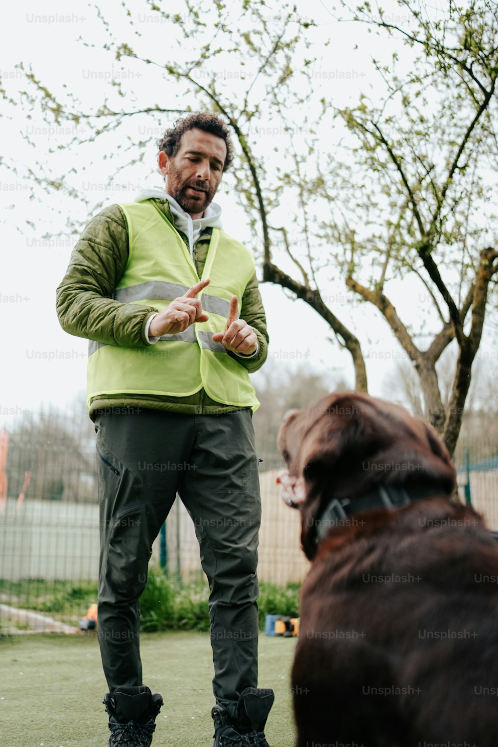 a man standing next to a brown dog
