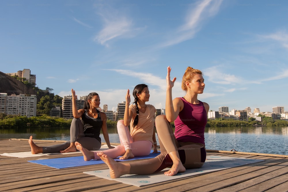 a group of women doing yoga on a dock