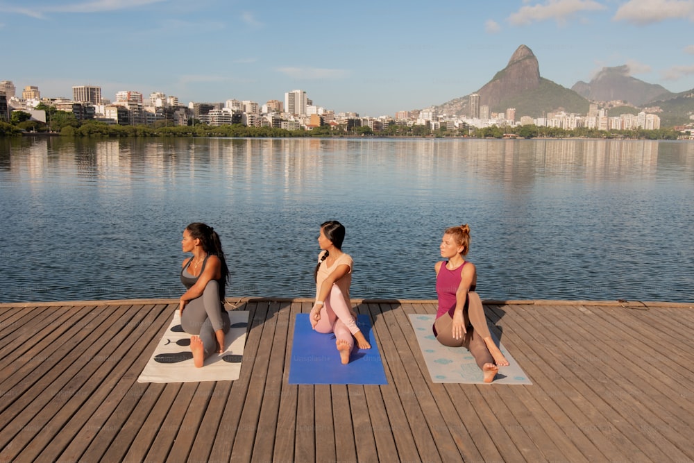 Eine Gruppe von Frauen, die Yoga auf einem Dock machen