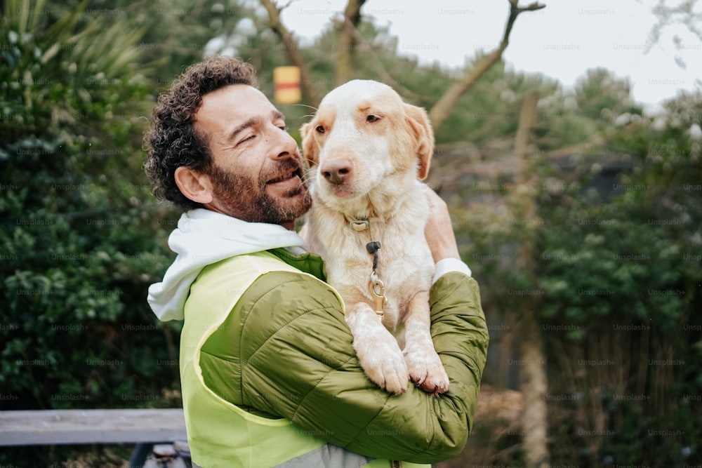 a man is holding a dog in his arms