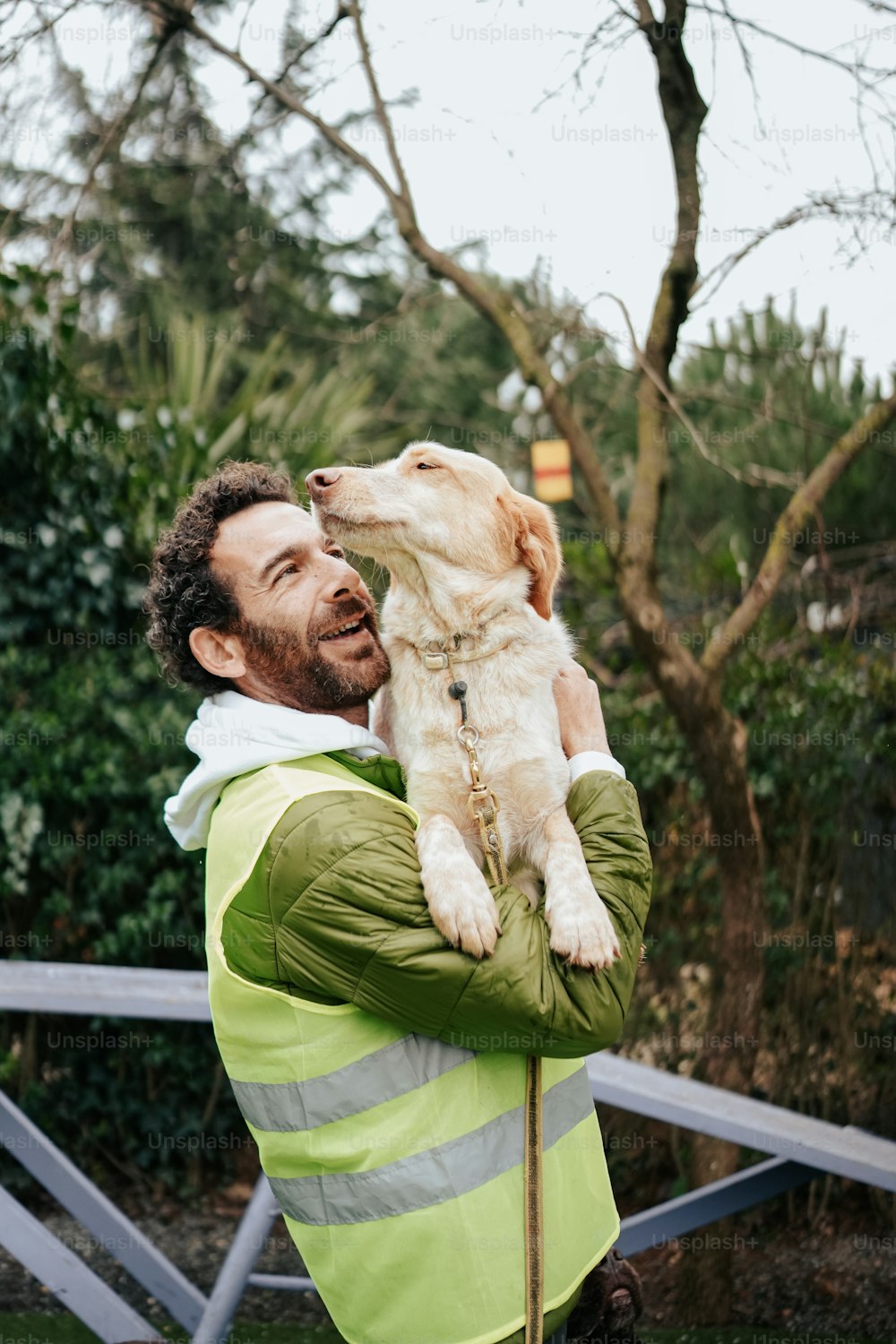 a man holding a puppy up to his face