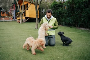 Un hombre arrodillado junto a tres perros