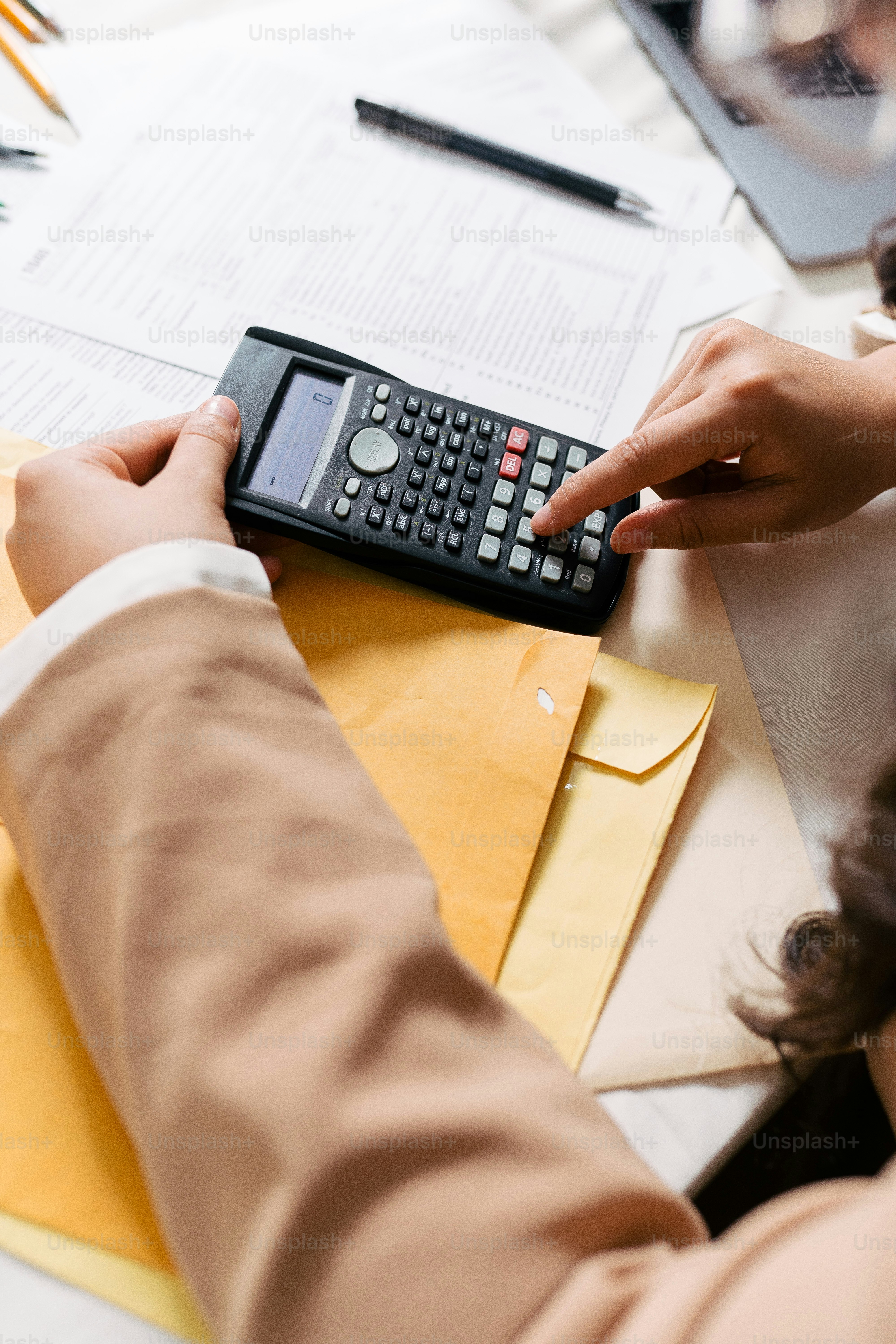 a person using a calculator on a desk