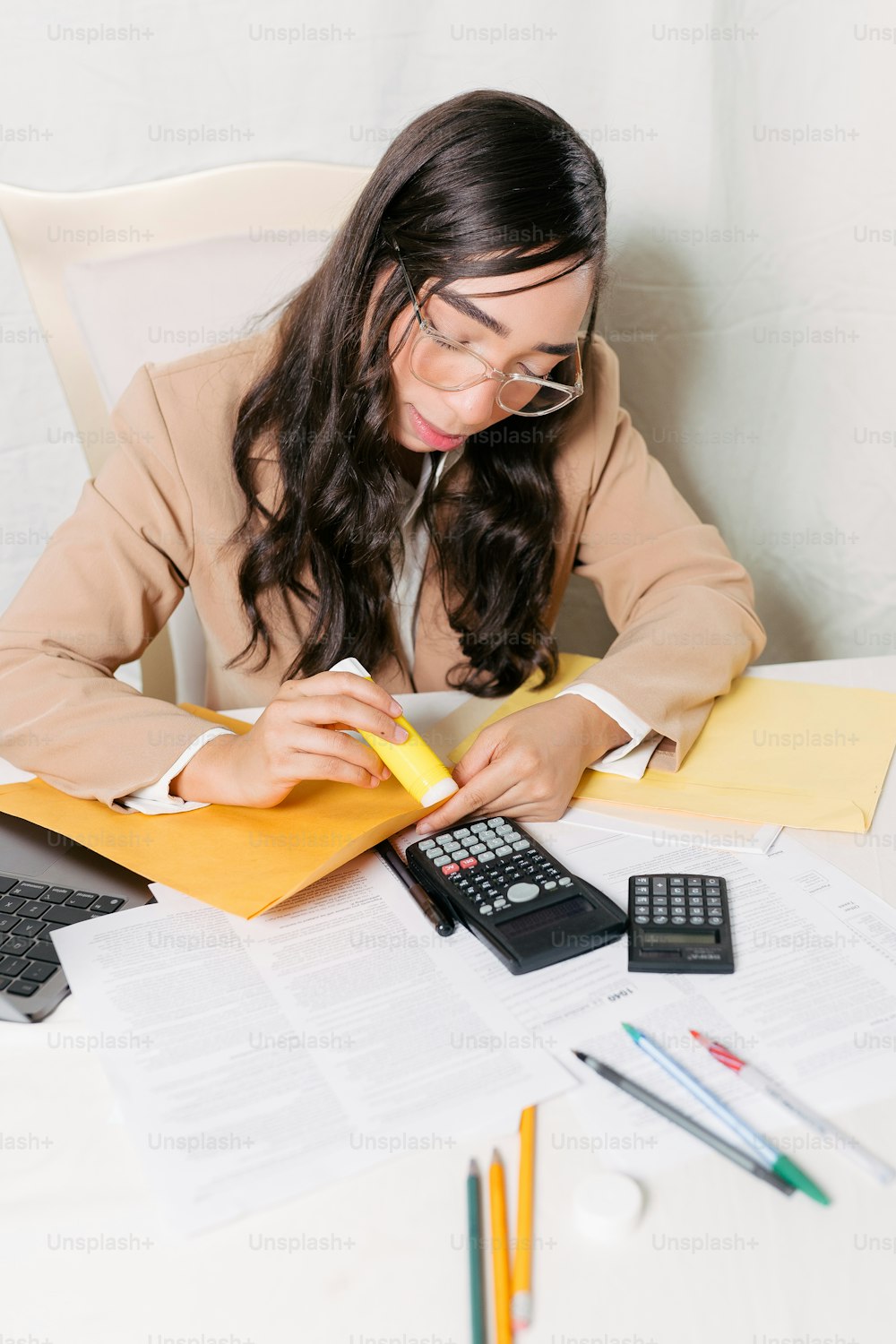 uma mulher sentada em uma mesa com uma calculadora e uma calculadora