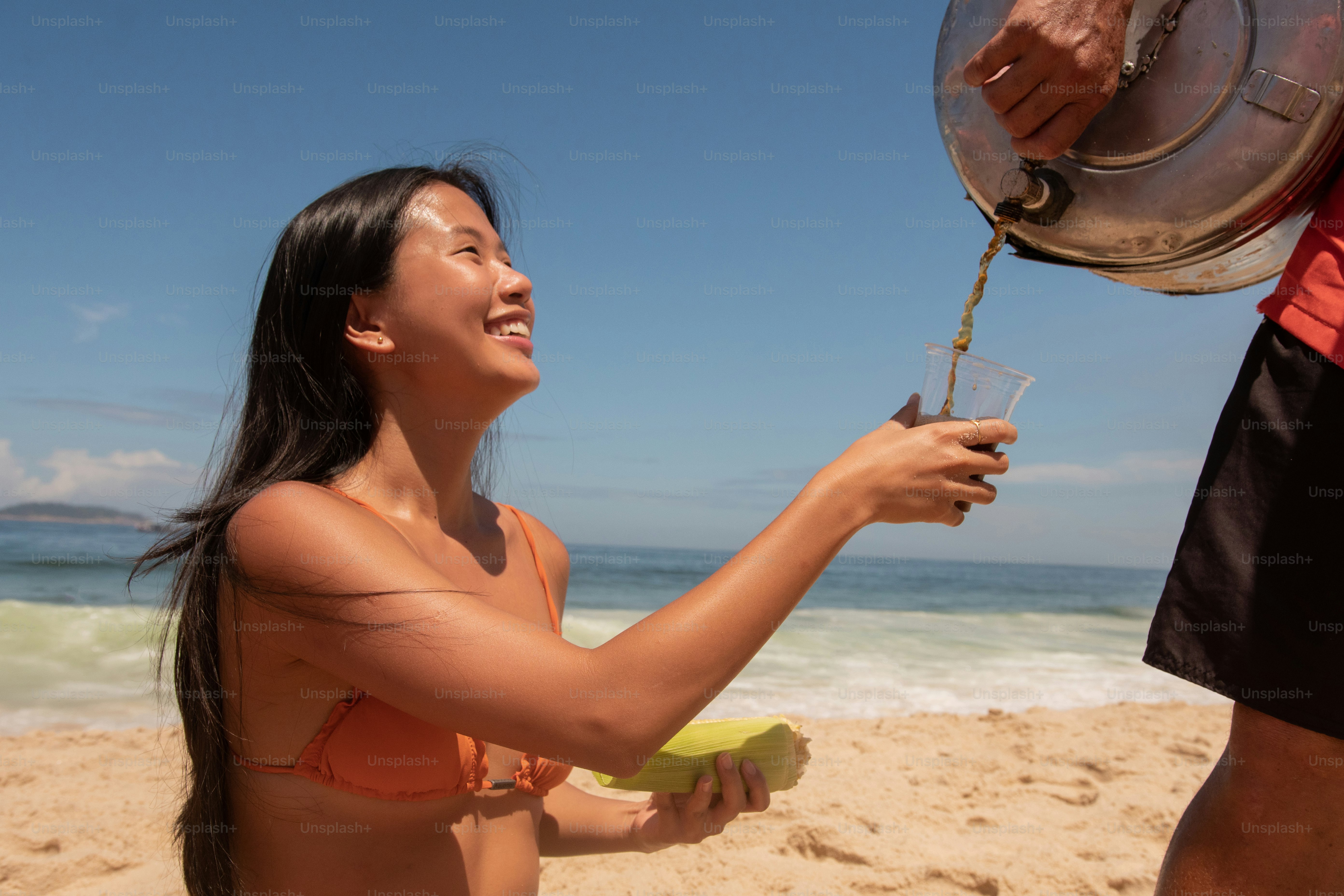 Una donna in bikini su una spiaggia che tiene una banana