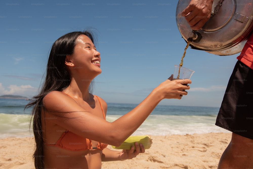 Une femme en bikini sur une plage tenant une banane
