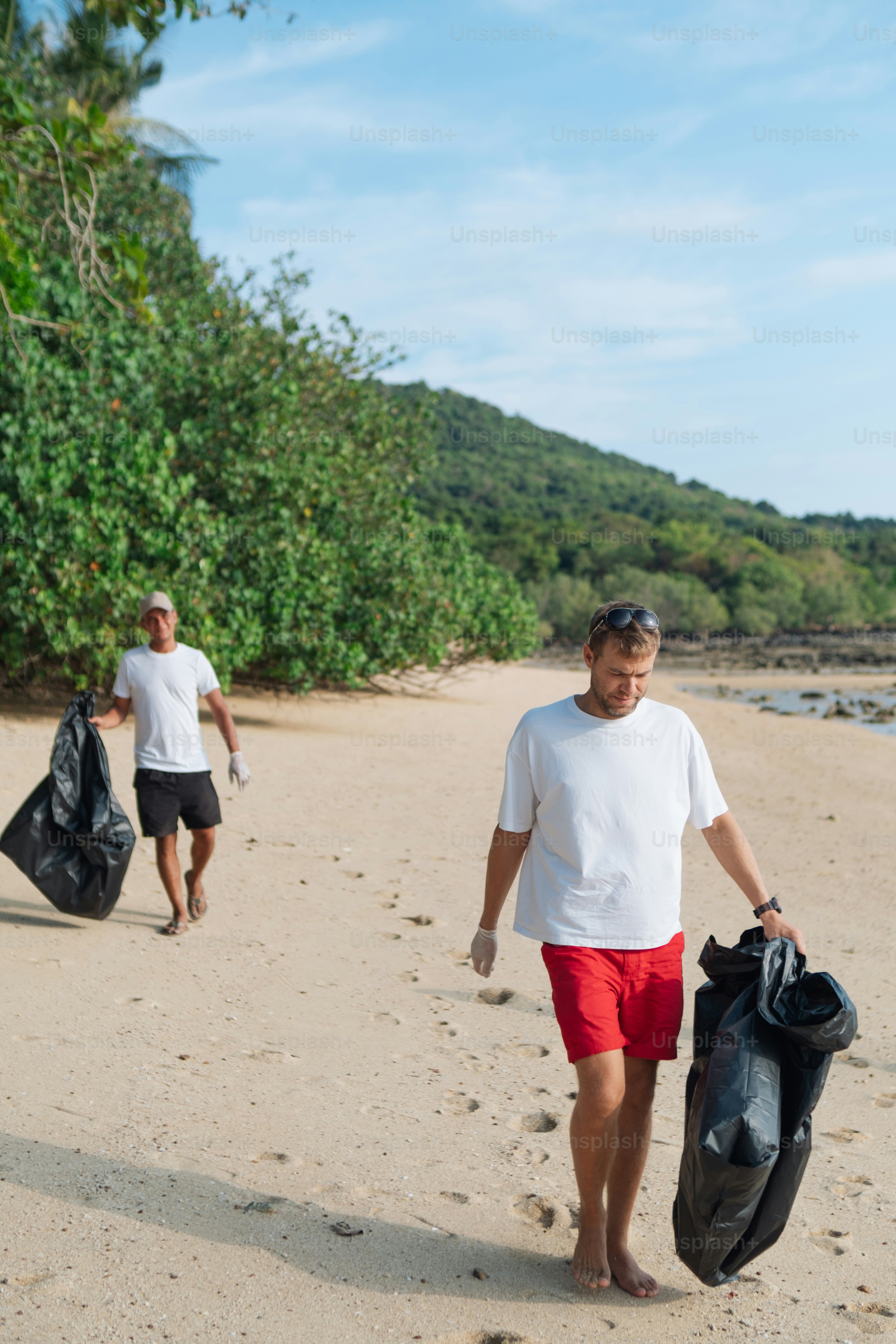 a man walking down a beach carrying a bag