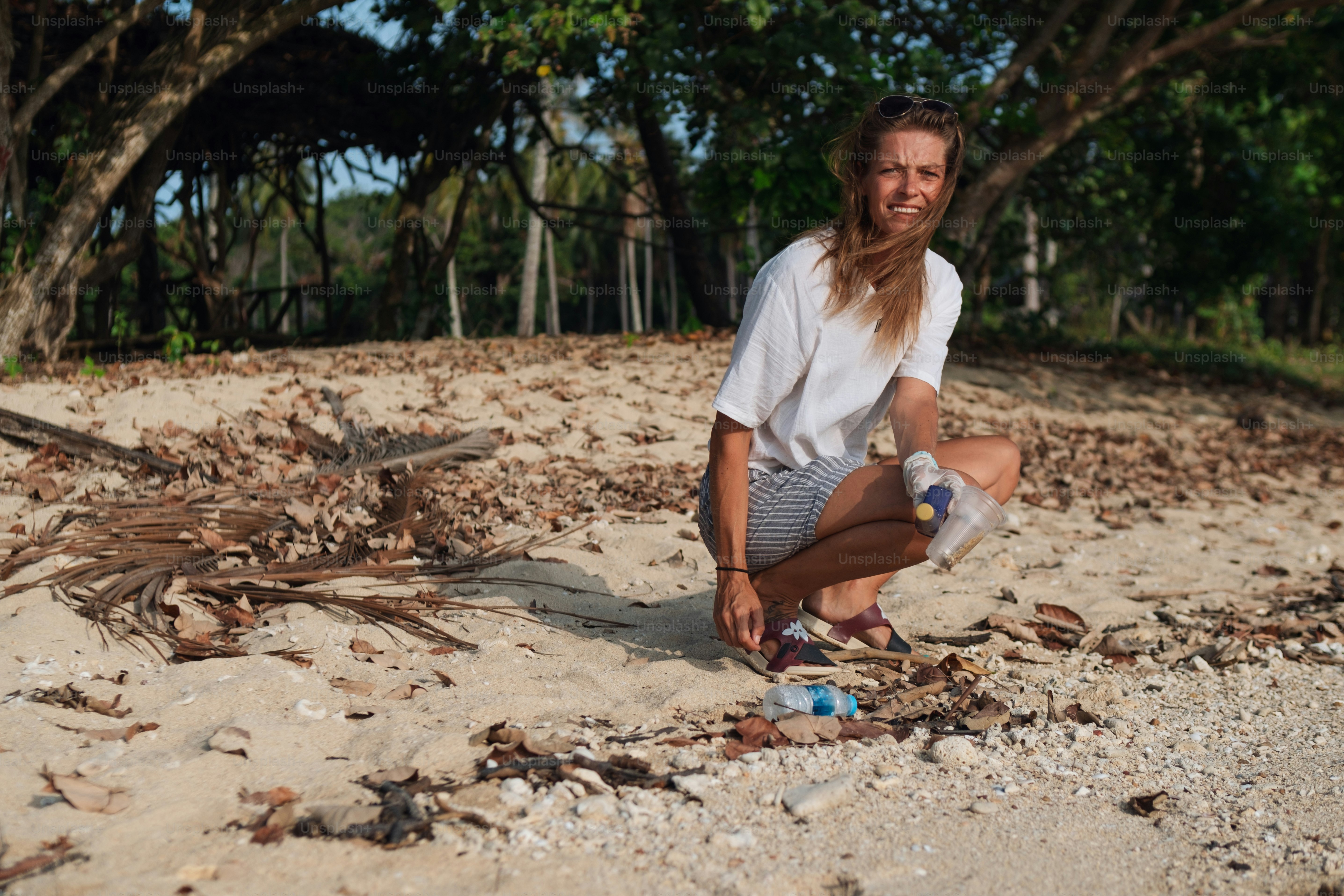 a man kneeling down on a sandy beach