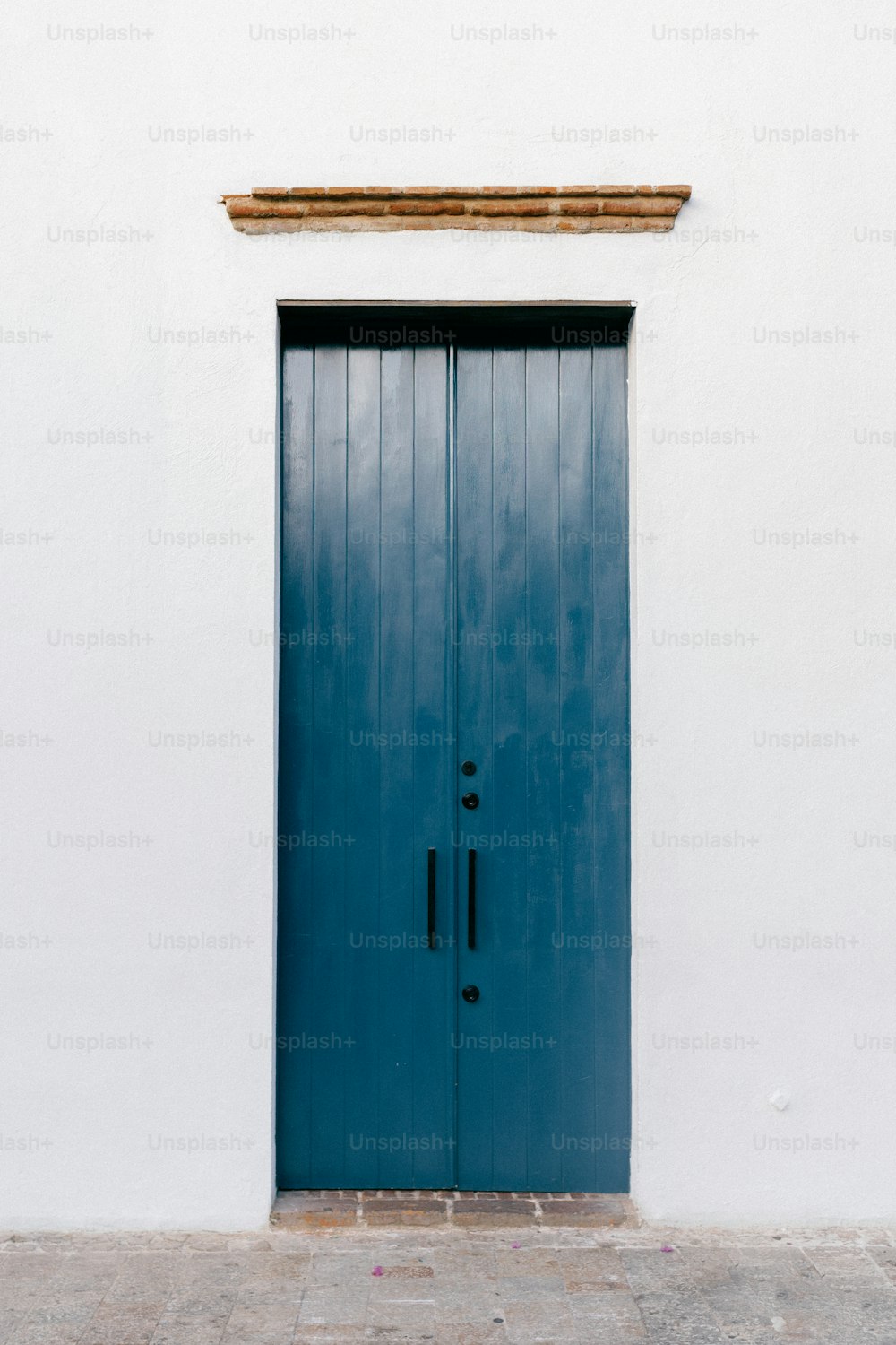 un bâtiment blanc avec une porte et une fenêtre bleues