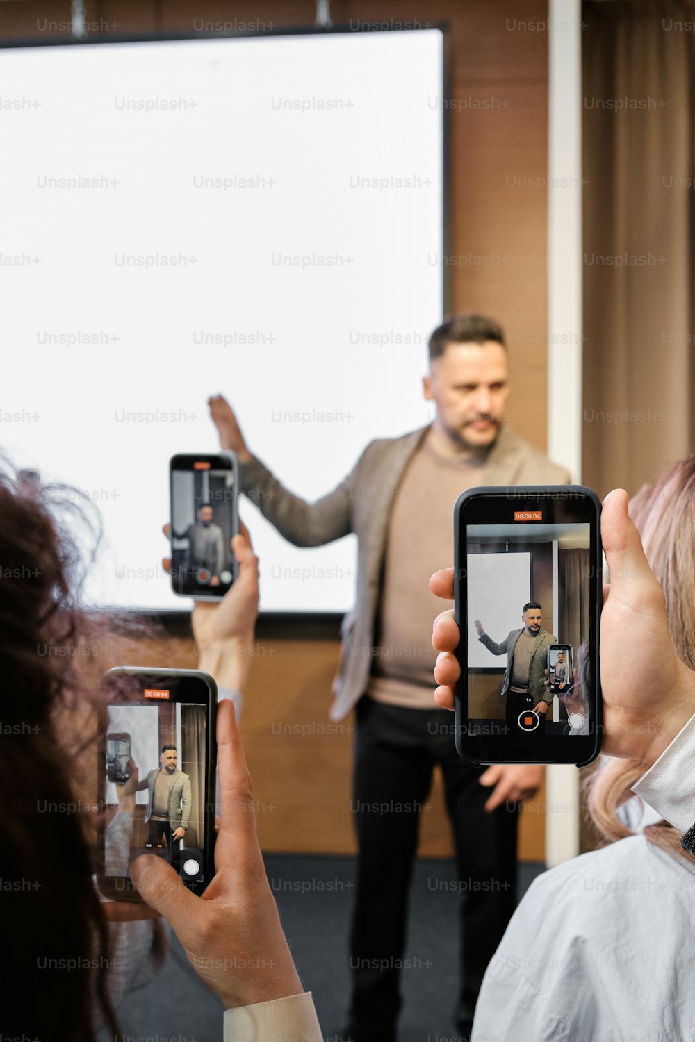 a group of people taking pictures with their cell phones