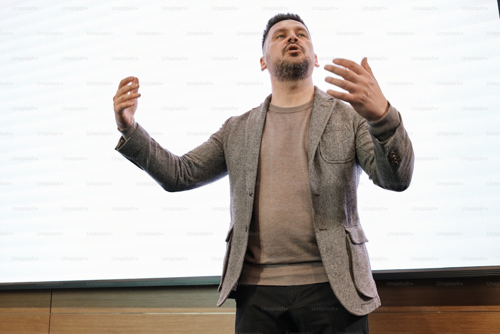 a man standing in front of a projection screen