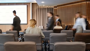 Un grupo de personas de pie alrededor de una sala de conferencias