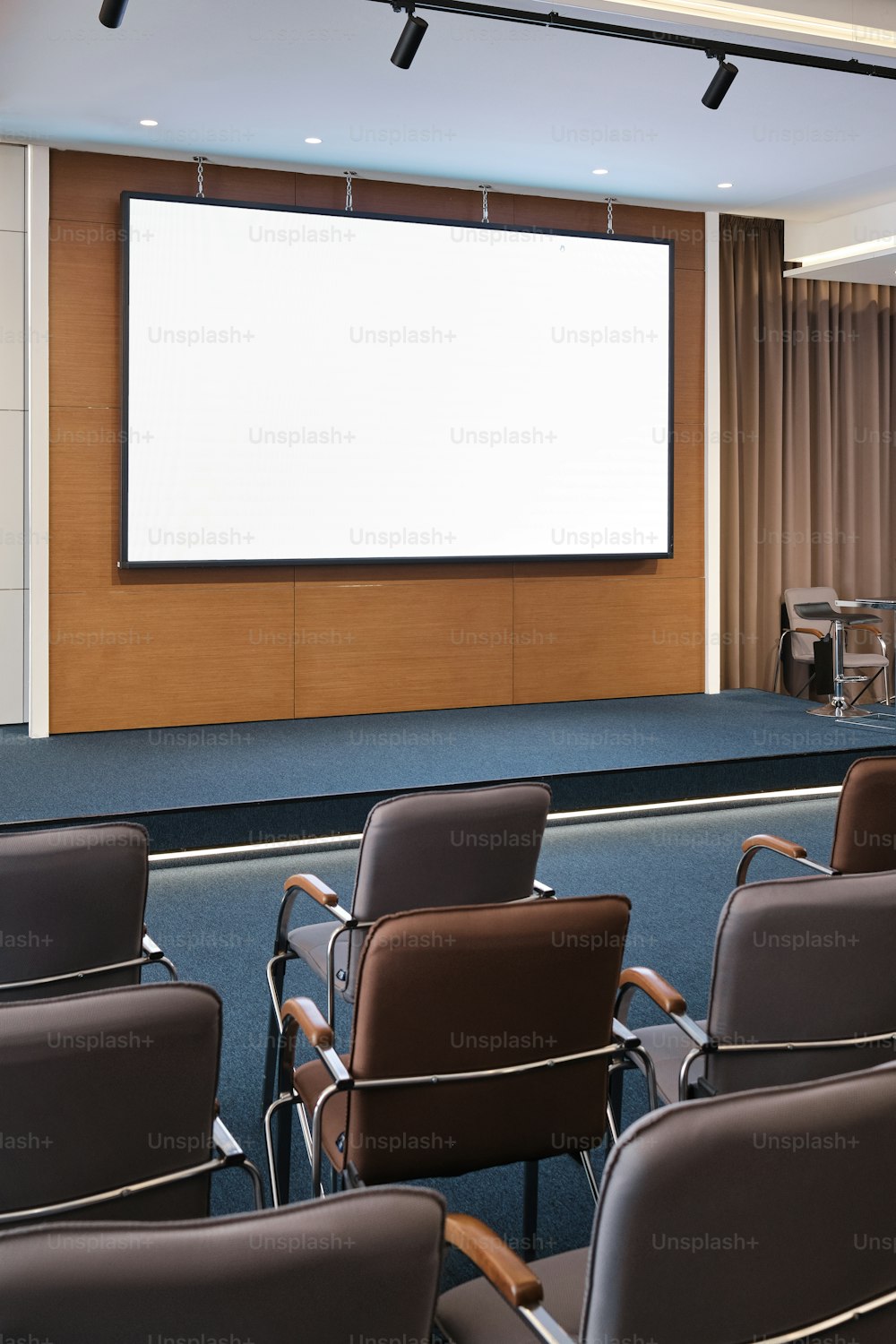 a large screen in a room with chairs