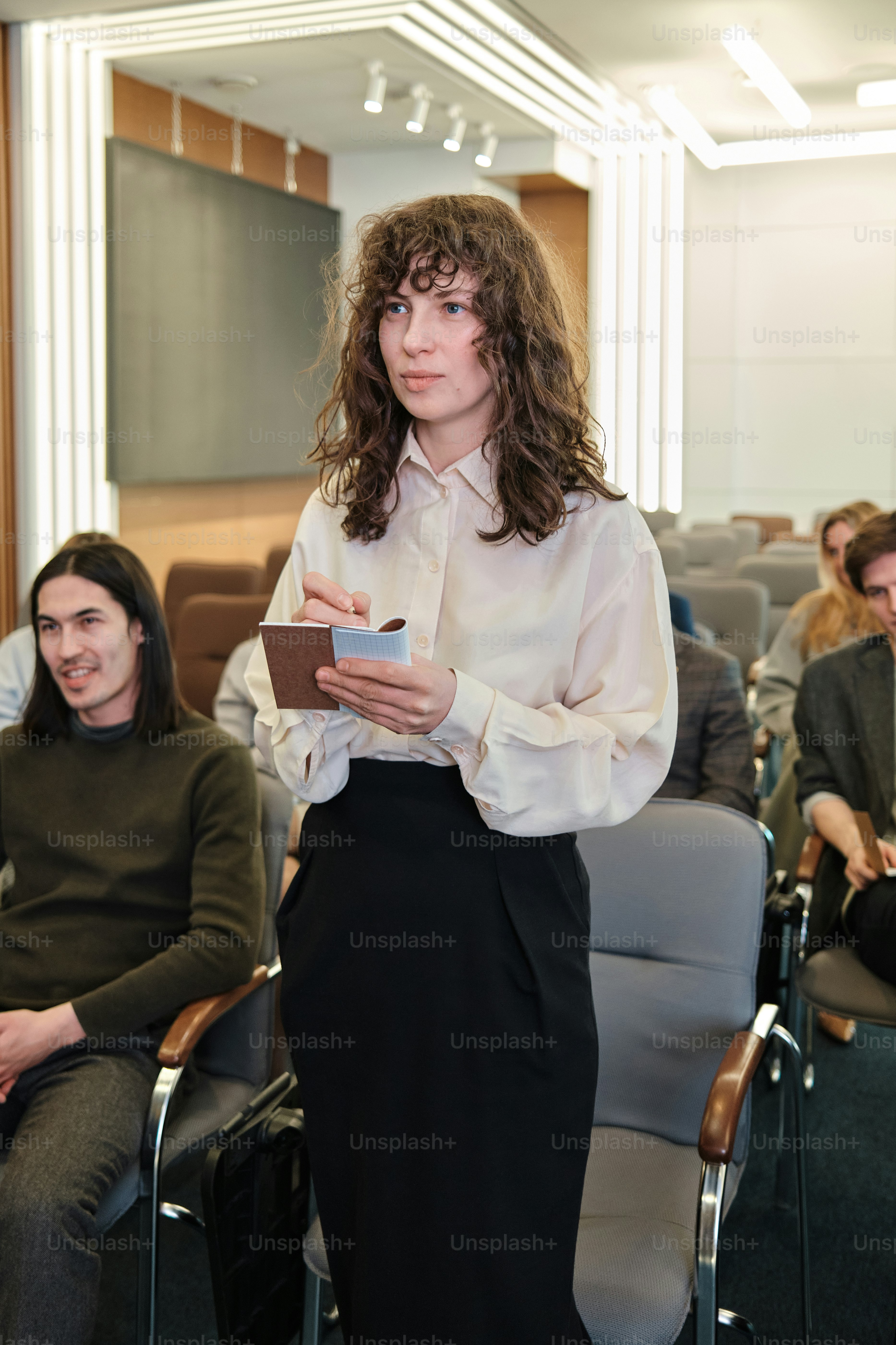 a woman standing in front of a group of people