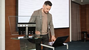 Un homme debout devant un ordinateur portable