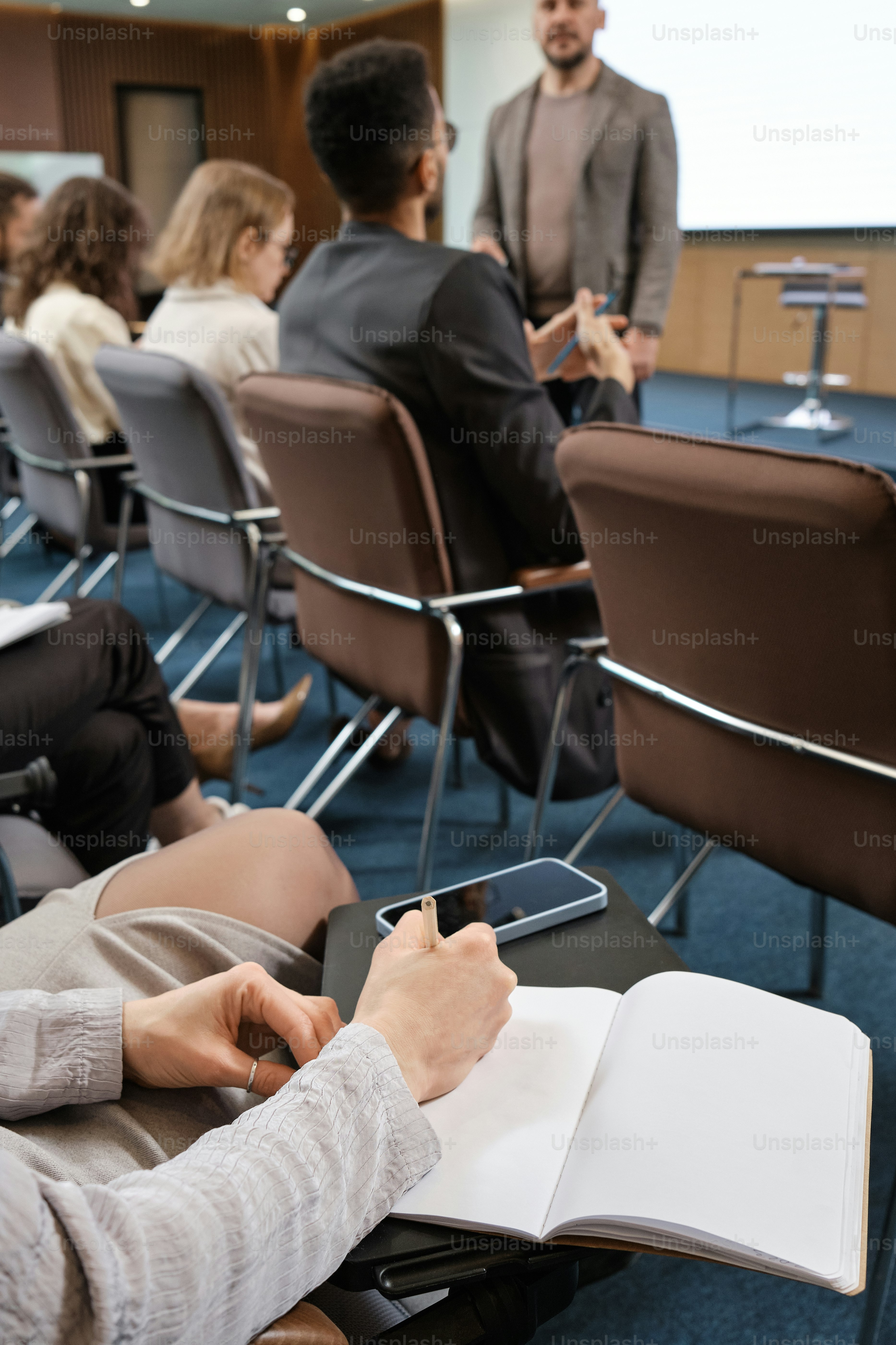 eine Gruppe von Menschen, die auf Stühlen in einem Raum sitzen