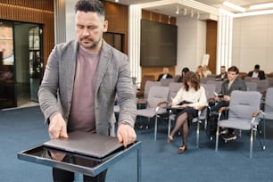 a man standing in front of a podium in a room full of people