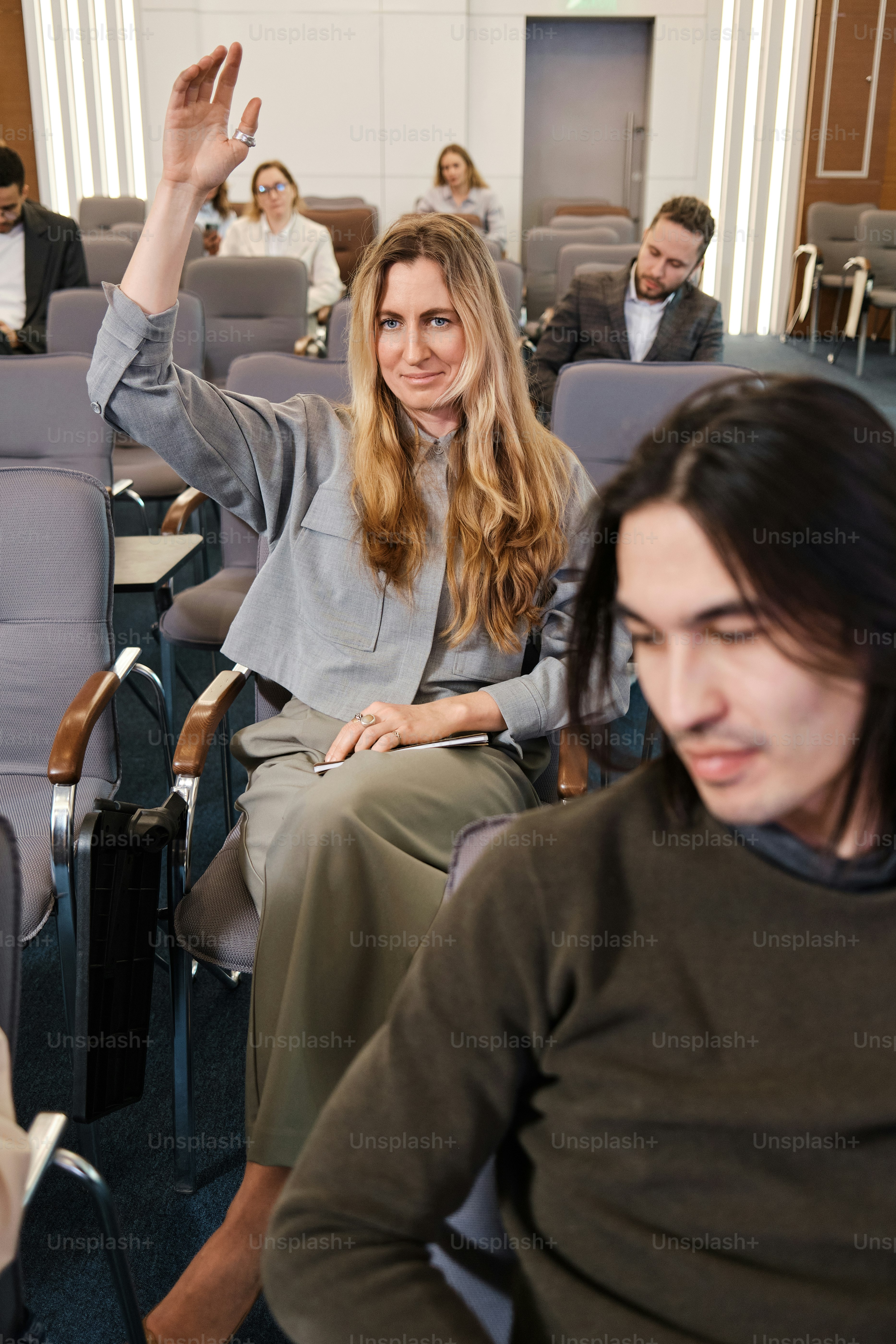 Eine Frau, die in einem Flugzeug sitzt und in die Kamera winkt