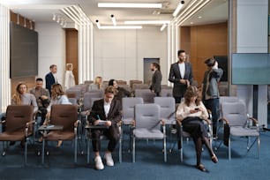 eine Gruppe von Menschen, die auf Stühlen in einem Raum sitzen