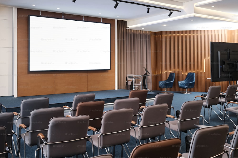 uma sala de conferências com cadeiras e uma tela de projetor