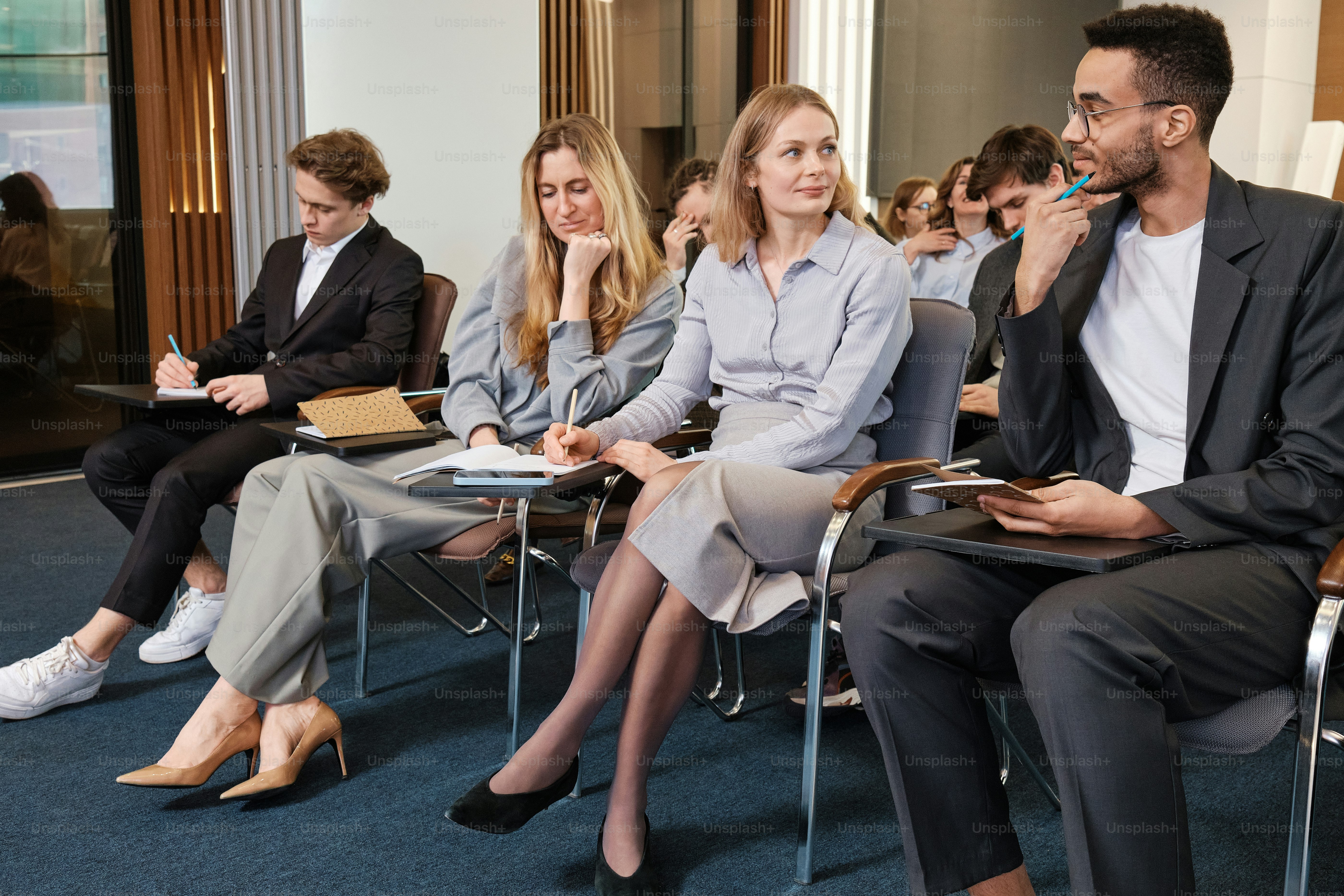 a group of people sitting next to each other interacting with confident people