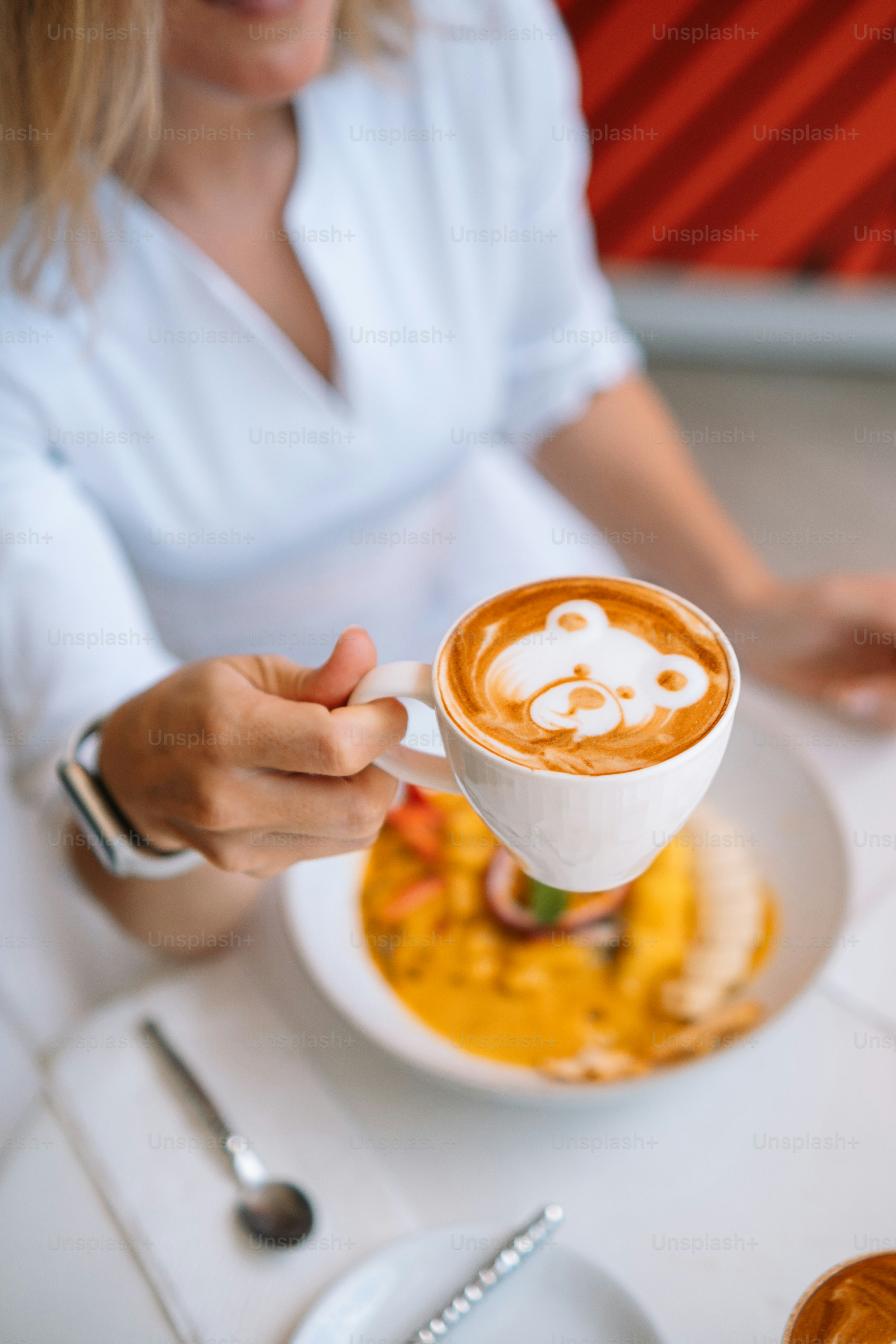 a woman is holding a cup of coffee