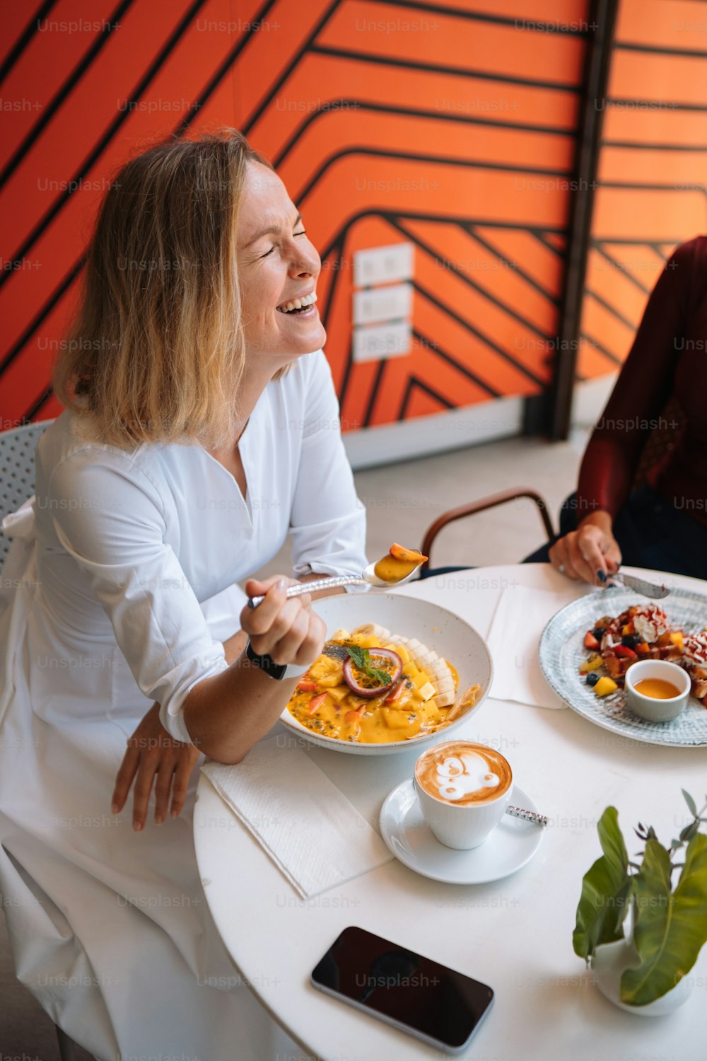 Un par de mujeres sentadas en una mesa con platos de comida
