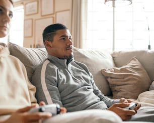 a man and a woman sitting on a couch playing a video game