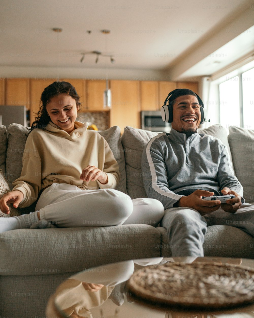Un hombre y una mujer sentados en un sofá jugando un videojuego