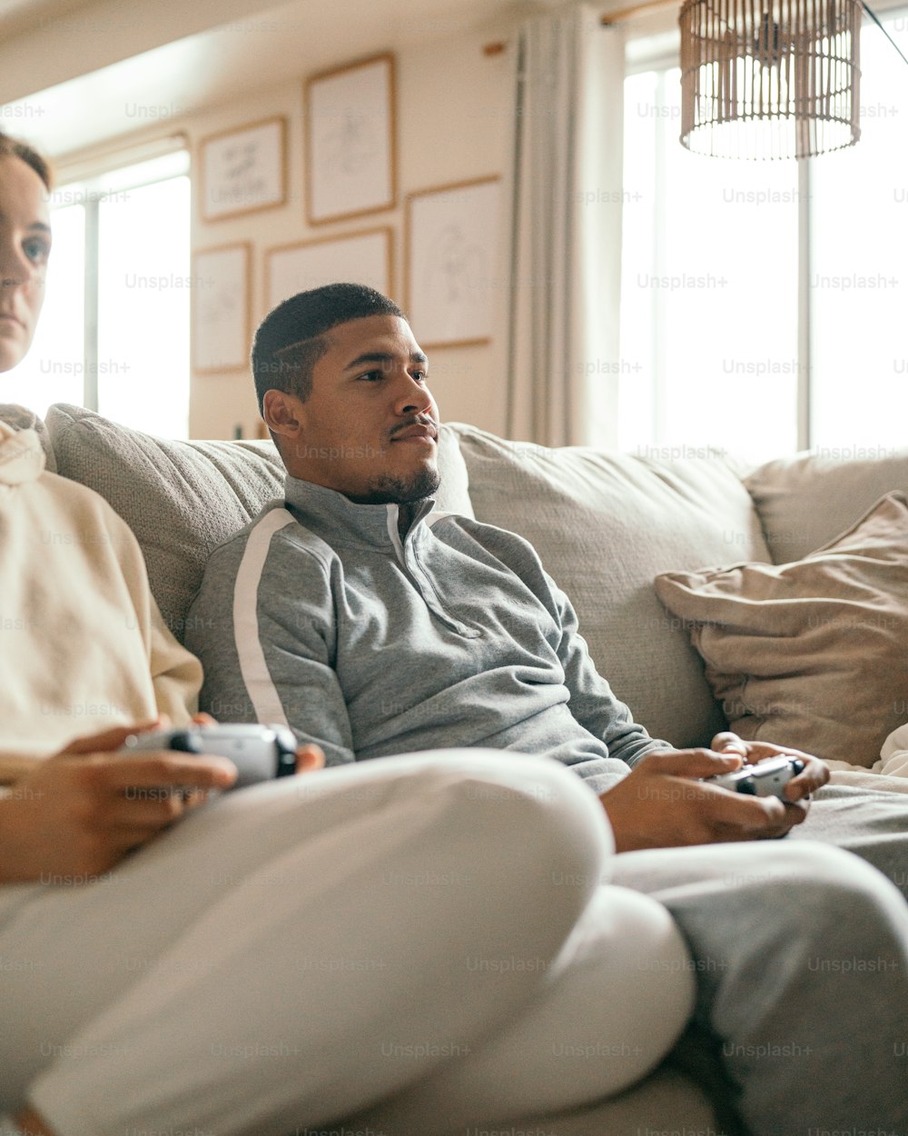 Zwei Männer, die auf einer Couch sitzen und Videospiele spielen