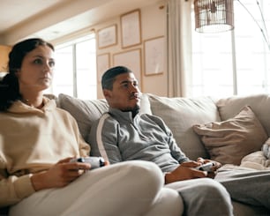 a man and woman sitting on a couch playing a video game