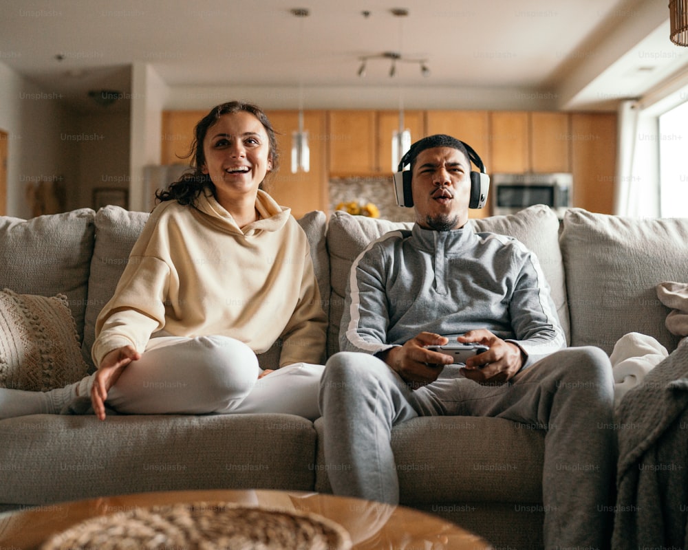 Un uomo e una donna seduti su un divano che giocano a un videogioco