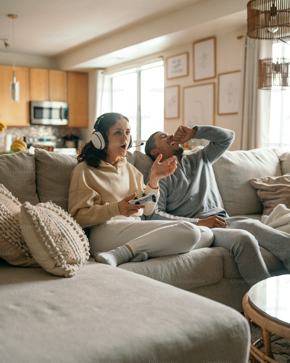 Un hombre y una mujer sentados en un sofá jugando un videojuego
