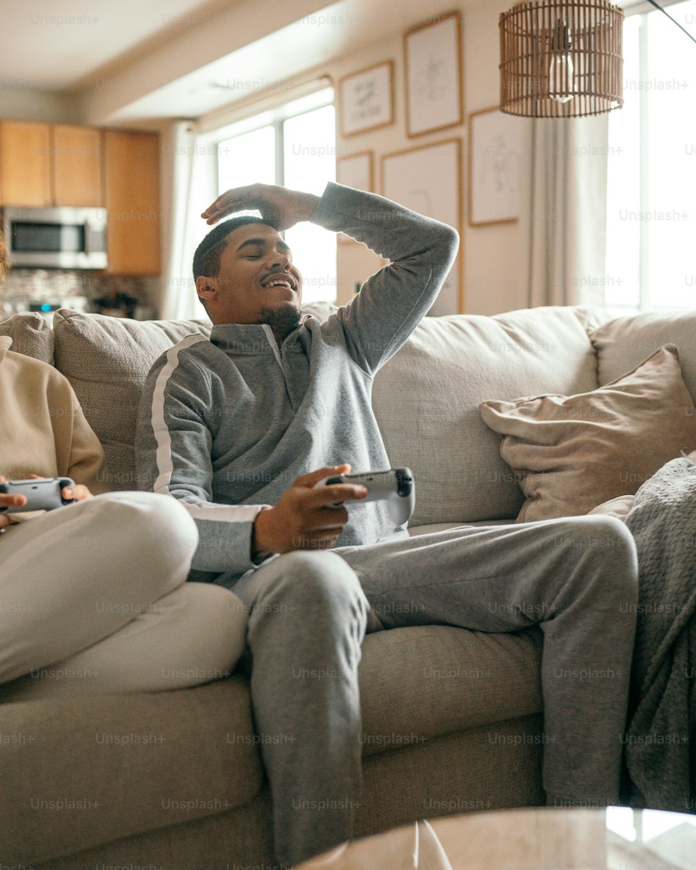 duas pessoas sentadas em um sofá jogando um videogame