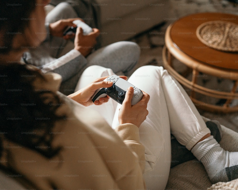 a woman sitting on a couch playing a video game