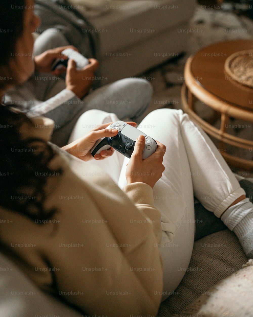 uma mulher sentada em um sofá jogando um videogame