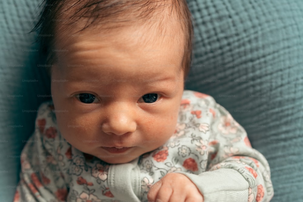 a close up of a baby laying on a bed